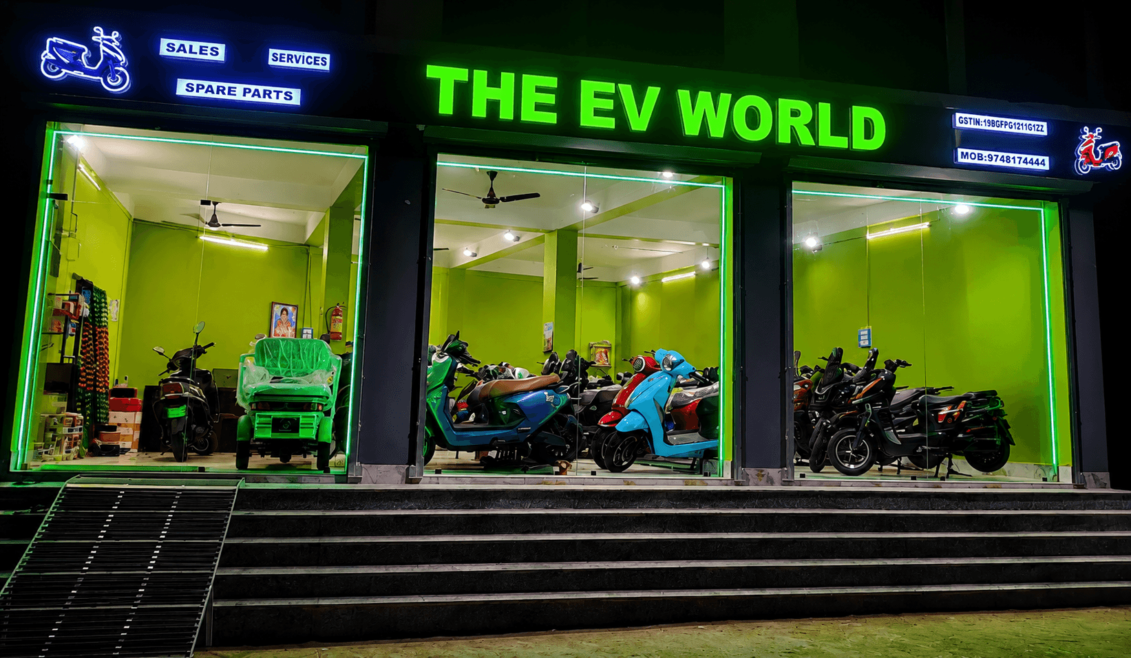 The EV World showroom storefront lit up at night